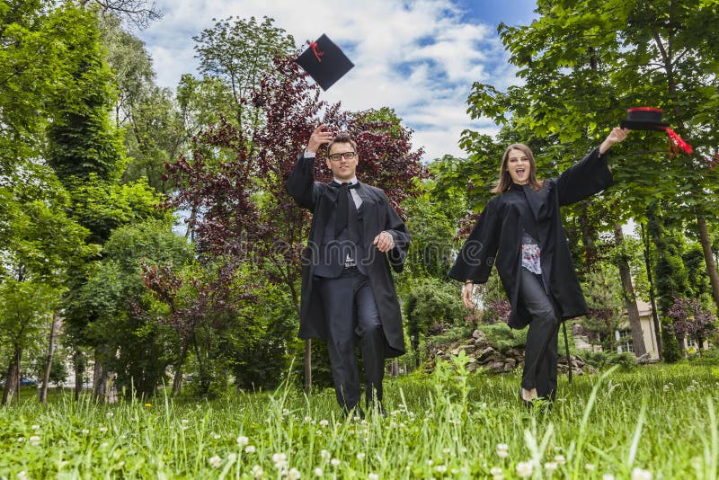 Lyckliga par i avläggande av examendagen arkivbild Lyckliga par i avläggande av examendagen arkivbild