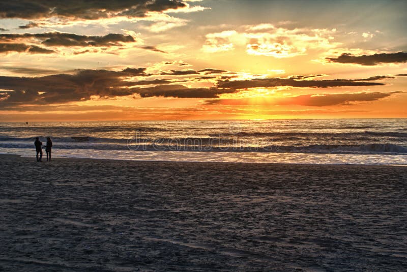 Lyckliga par som går på stranden på soluppgång för ferietid royaltyfri fotografi Lyckliga par som går på stranden på soluppgång för ferietid royaltyfri fotografi