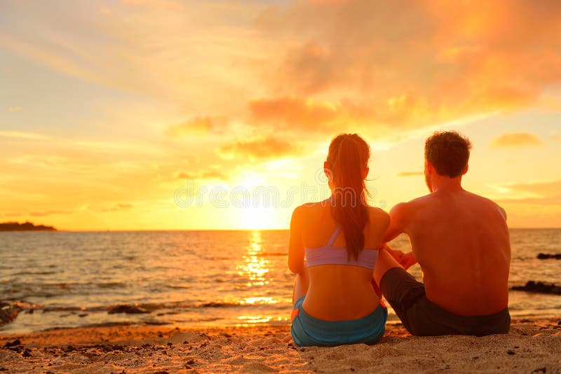 Lyckliga romantiska par som tycker om solnedgång på stranden fotografering för bildbyråer Lyckliga romantiska par som tycker om solnedgång på stranden fotografering för bildbyråer