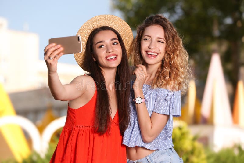 Lyckliga unga kvinnor som utomhus tar selfie fotografering för bildbyråer Lyckliga unga kvinnor som utomhus tar selfie fotografering för bildbyråer
