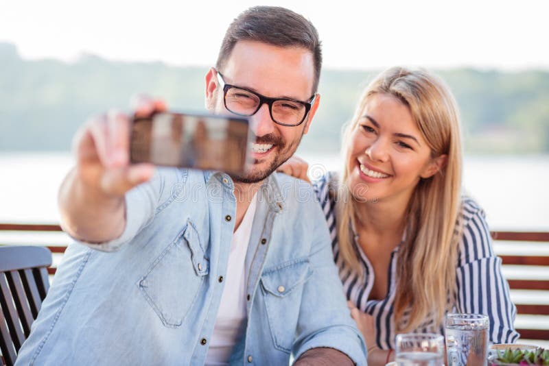 Lyckliga unga par som tar en selfie i ett kafé arkivbilder Lyckliga unga par som tar en selfie i ett kafé arkivbilder