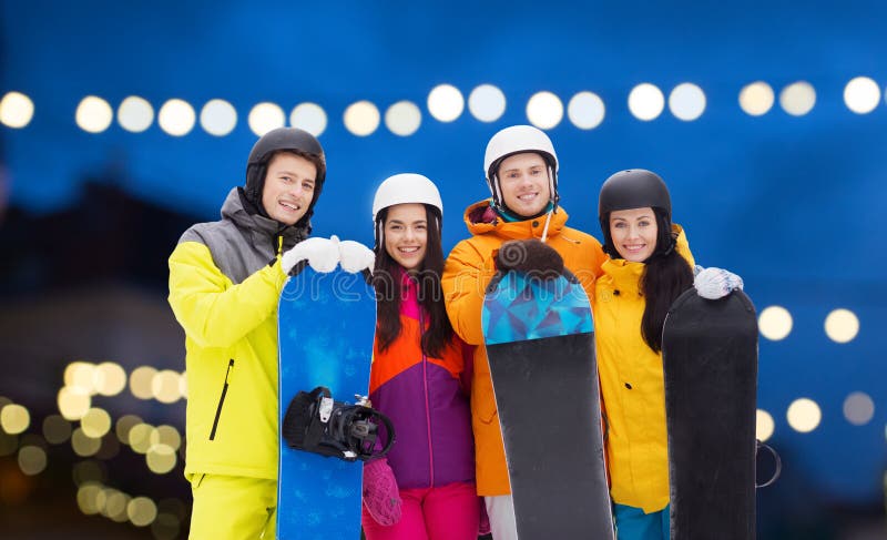 Lyckliga vänner i hjälmar med snowboards fotografering för bildbyråer