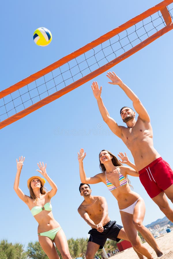Lyckliga vänner som spelar strandsalva royaltyfria foton Lyckliga vänner som spelar strandsalva royaltyfria foton