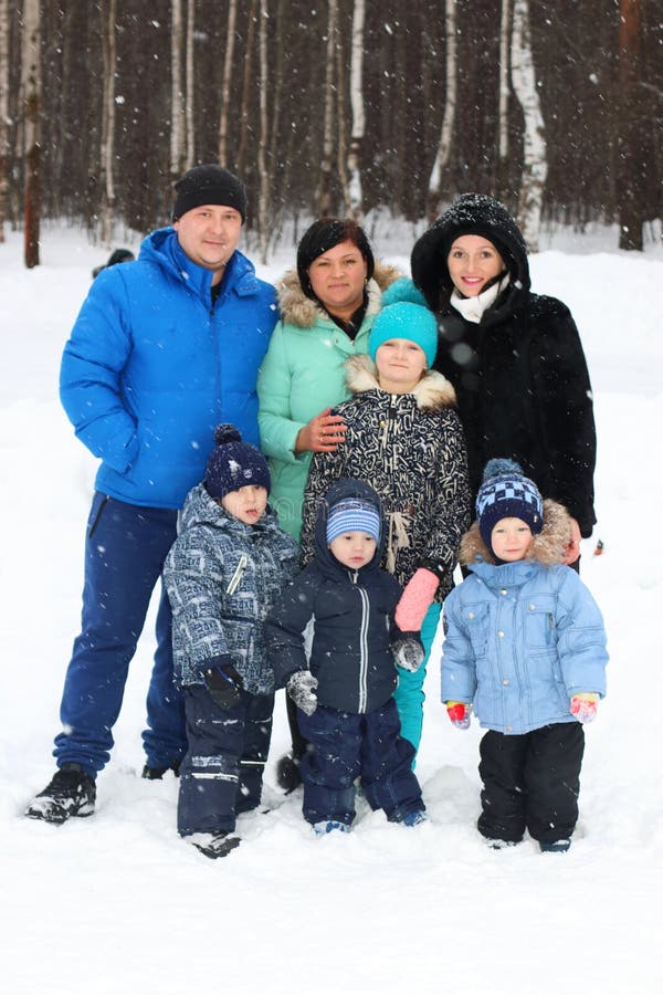 Lyckliga vänner & x28; två familjer - sju people& x29; posera i vinterdag royaltyfri foto Lyckliga vänner & x28; två familjer - sju people& x29; posera i vinterdag royaltyfri foto