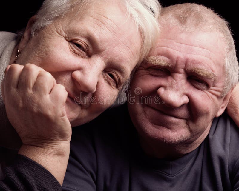 Lyckliga äldre par på en svart bakgrund fotografering för bildbyråer Lyckliga äldre par på en svart bakgrund fotografering för bildbyråer