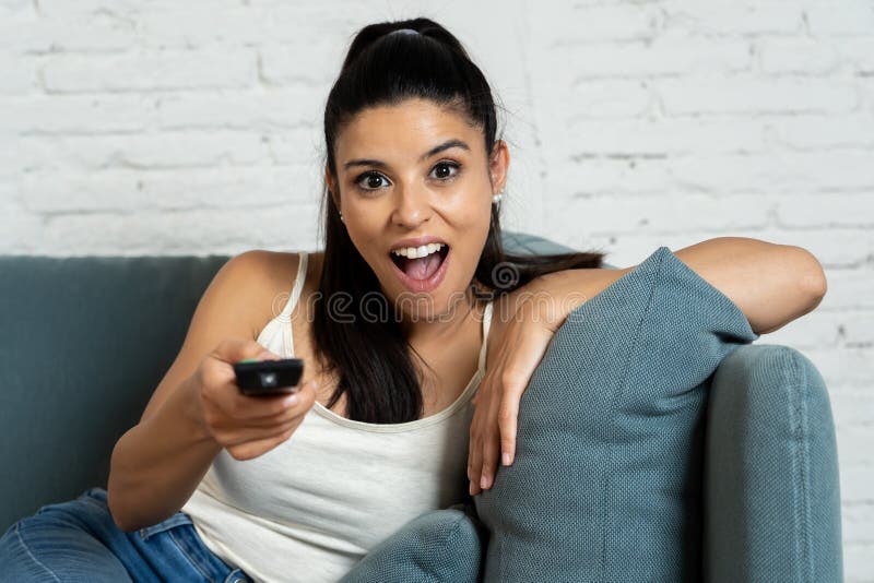 Lyckligt hemmastatt för latinsk nätt kvinna hålla ögonen på televisionen arkivfoto Lyckligt hemmastatt för latinsk nätt kvinna hålla ögonen på televisionen arkivfoto