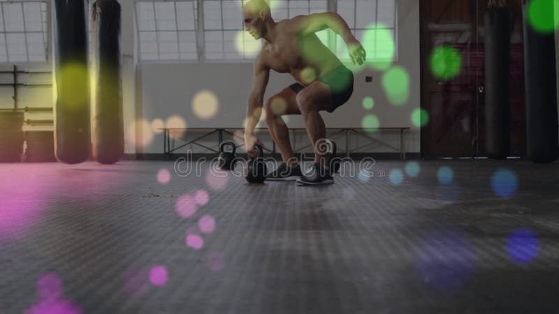 Lyftande kettlebells, skjortfri man som tränar över färgstarka bokeh-ljus animering lager videofilmer