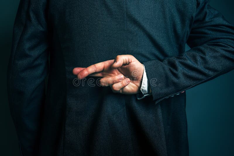 Lying businessman holding fingers crossed behind his back stock images