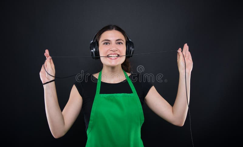 Lyssnande musik för lycklig flickasäljare från hennes hörlurar fotografering för bildbyråer Lyssnande musik för lycklig flickasäljare från hennes hörlurar fotografering för bildbyråer