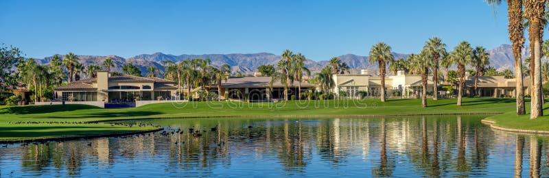 Luxury homes along a golf course in Palm Desert California during a beautiful sunrise over a water feature on a golf. Luxury homes along a golf course in Palm Desert California during a beautiful sunrise over a water feature on a golf.