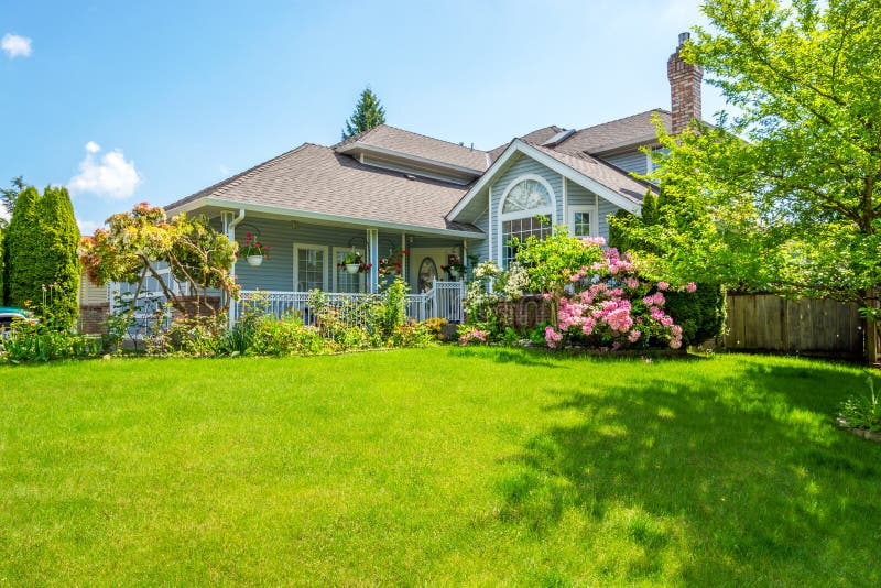 Entrance of a luxury house with a patio and beautiful landscaping on a bright, sunny day. Home exterior. Entrance of a luxury house with a patio and beautiful landscaping on a bright, sunny day. Home exterior.