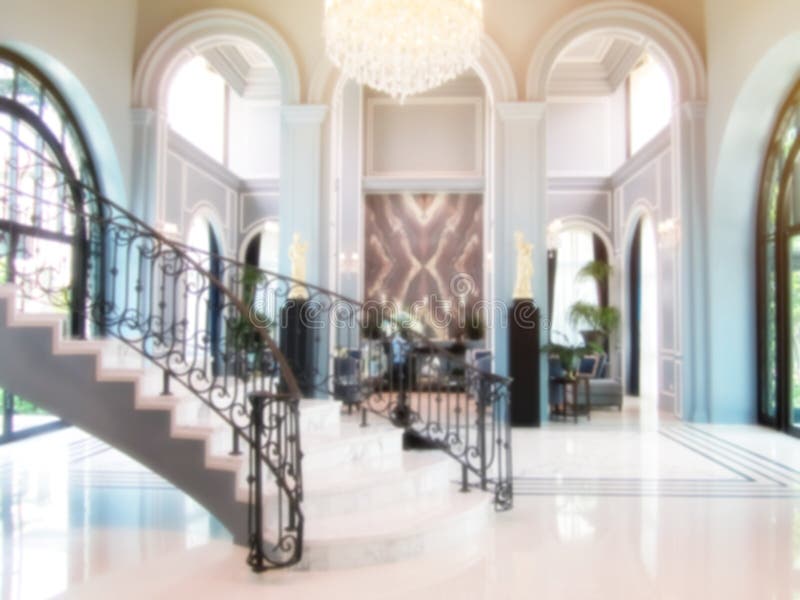 Lyxlobby med elegant böjd trappa, öppet utrymme inuti grekisk stil, konceptets suddiga bakgrund kan användas för visning. arkivbild Lyxlobby med elegant böjd trappa, öppet utrymme inuti grekisk stil, konceptets suddiga bakgrund kan användas för visning. arkivbild
