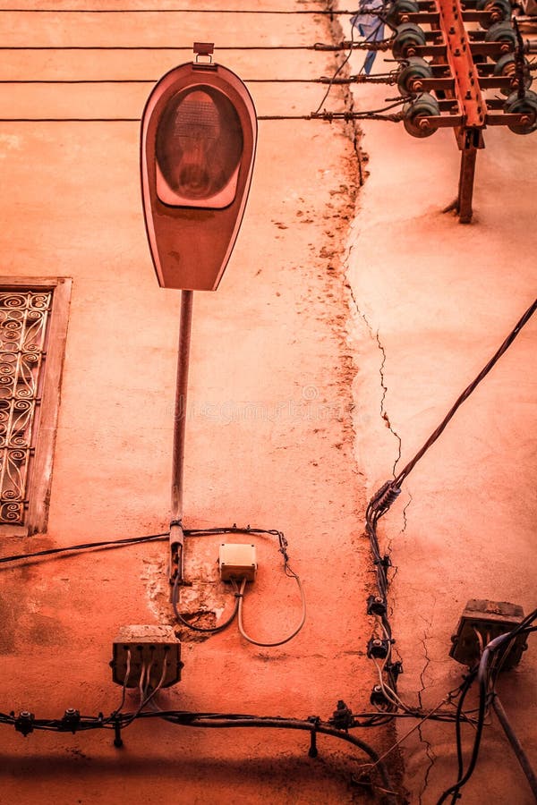 Lámpara de calle en la pared sucia con las líneas de suministro del poder foto de archivo Lámpara de calle en la pared sucia con las líneas de suministro del poder foto de archivo