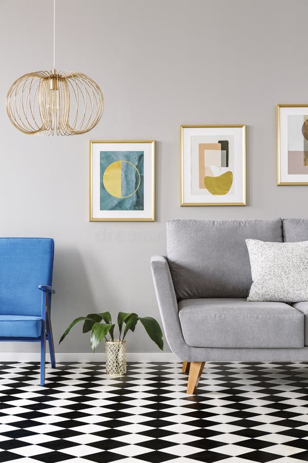 Lámpara del oro sobre la butaca azul en el interior plano w del piso a cuadros fotos de archivo libres de regalías Lámpara del oro sobre la butaca azul en el interior plano w del piso a cuadros fotos de archivo libres de regalías