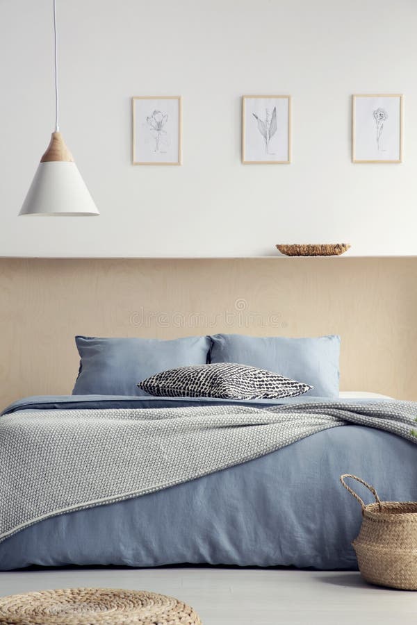 Lámpara sobre cama azul con las almohadas en interior del dormitorio del boho con p imagen de archivo Lámpara sobre cama azul con las almohadas en interior del dormitorio del boho con p imagen de archivo