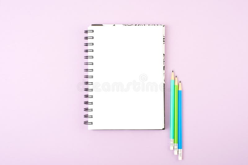 Lápices en blanco del cuaderno y del color en fondo rosado fotografía de archivo Lápices en blanco del cuaderno y del color en fondo rosado fotografía de archivo
