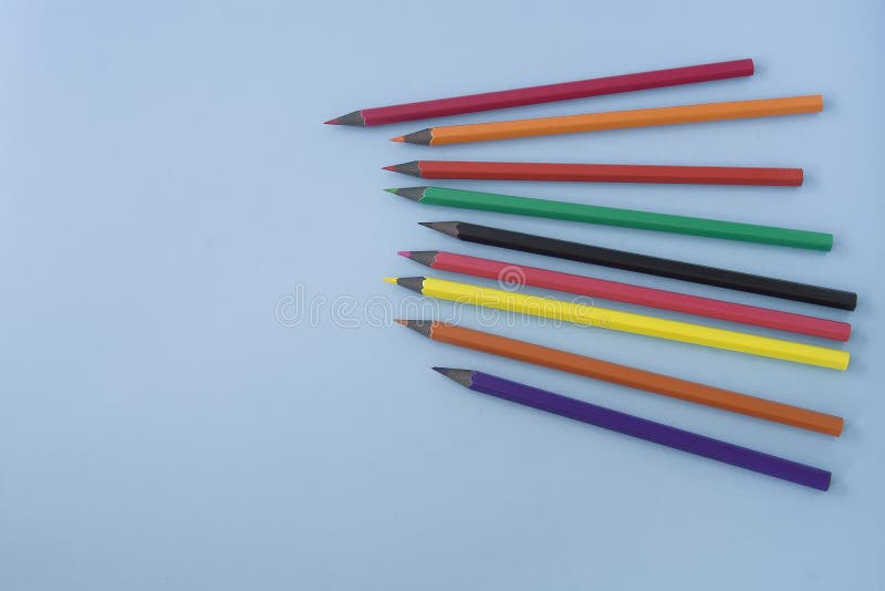 Lápis coloridos colocados na mesa azul pastel, espaço para o texto em t fotografia de stock Lápis coloridos colocados na mesa azul pastel, espaço para o texto em t fotografia de stock