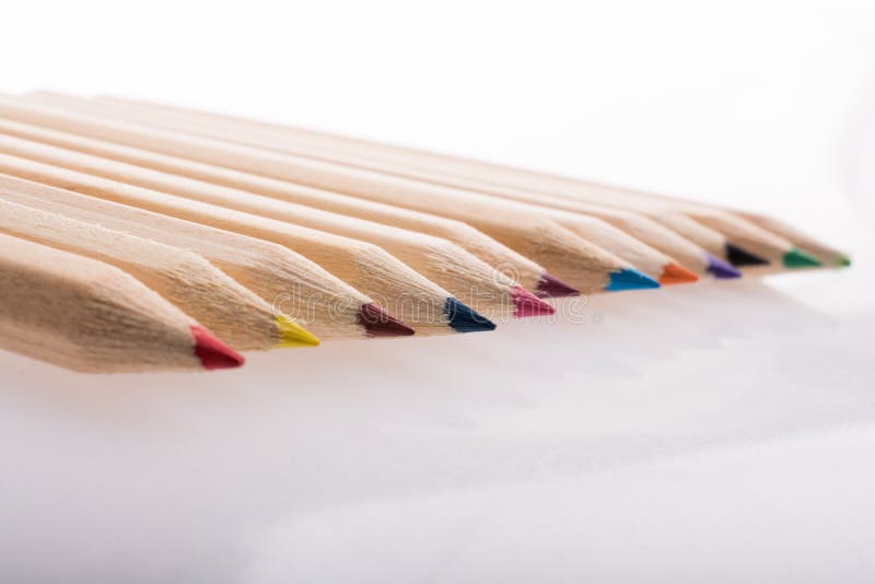Lápis coloridos em uma fileira no fundo branco fotografia de stock Lápis coloridos em uma fileira no fundo branco fotografia de stock
