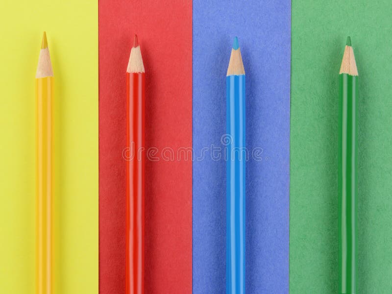 Overhead view of four colored pencils on matching colored paper. Closeup in horizontal format. Back to School concept. Overhead view of four colored pencils on matching colored paper. Closeup in horizontal format. Back to School concept.