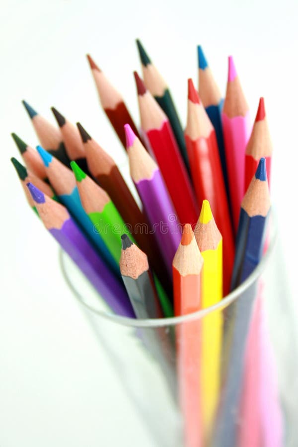 A glass containing brightly coloured pencils. A glass containing brightly coloured pencils