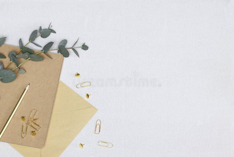Lápis dourado, clipes de papel, pinos, nota, envelope, ramo do eucalipto na textura branca imagem de stock royalty free Lápis dourado, clipes de papel, pinos, nota, envelope, ramo do eucalipto na textura branca imagem de stock royalty free