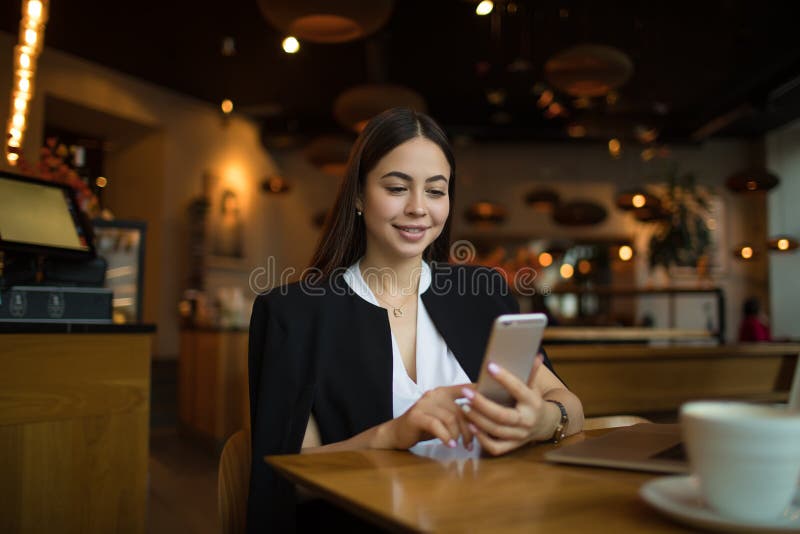 Lächeln hübsche weibliche Manager online chatten auf Handys stockbild