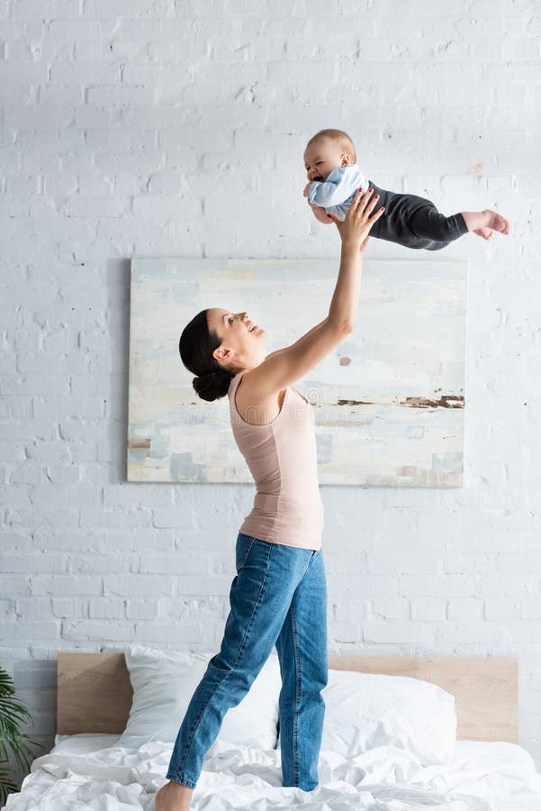Lächeln Mutter, die barfüßig Säuglingssohn hält lizenzfreies stockbild