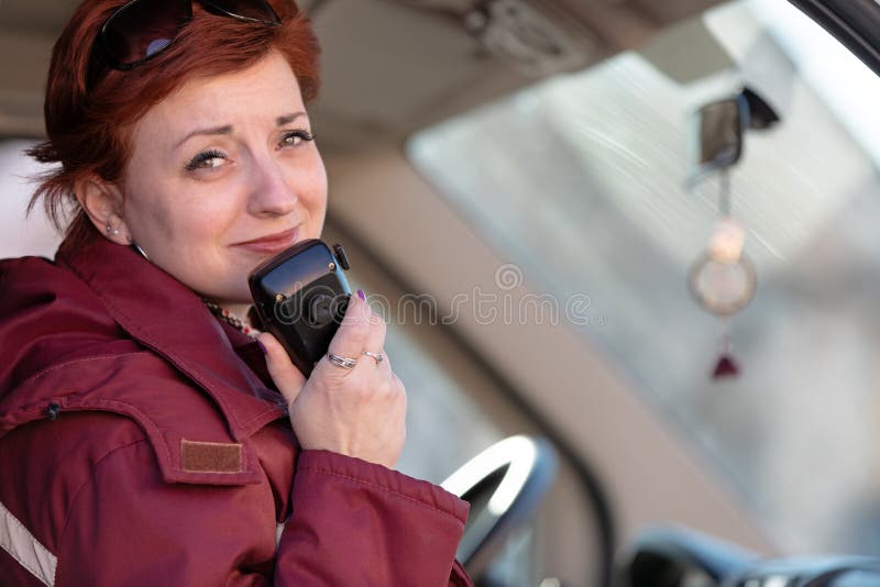 Lächeln weibliche Sanitäterarbeitskraft, die während der Sitzung im ems-Radiobericht Krankenwagenfahrerhaus macht
