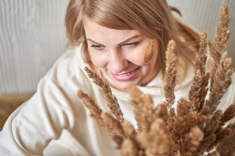 Lächelnd kaukasisches erwachsenes Weibchen mit Weizenstalken und natürlichem Make-up in gemütlicher lizenzfreies stockbild