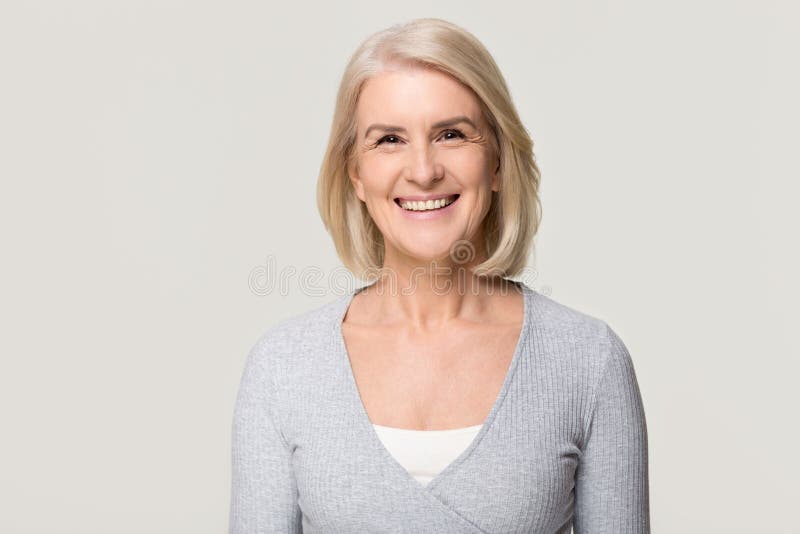 Lächelnd reife Frau Blick auf Kamera isoliert auf grauen Hintergrund