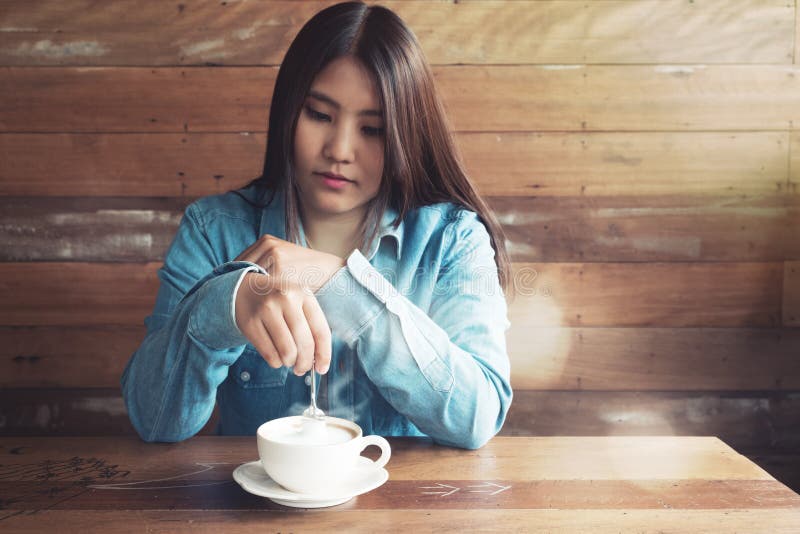 Lächelnde asiatische Frau mit heißer Kaffeetasse an der Kaffeestube lizenzfreies stockfoto Lächelnde asiatische Frau mit heißer Kaffeetasse an der Kaffeestube lizenzfreies stockfoto