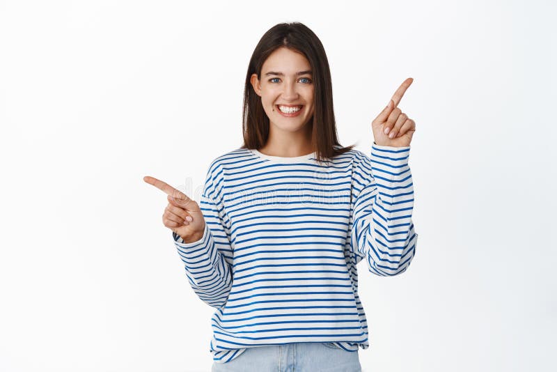 Lächelnde Brunette Frau zeigt Auswahlen, die links und rechts seitlich Logo oder Promo Verkauf weiß Hintergrund lizenzfreies stockfoto