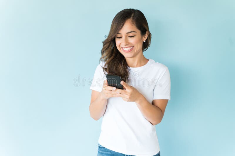 Lächelnde Frau unter Verwendung des Handys auf farbigem Hintergrund lizenzfreie stockfotos Lächelnde Frau unter Verwendung des Handys auf farbigem Hintergrund lizenzfreie stockfotos