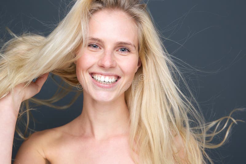 Lächelnde junge blonde Frau mit dem Schlaghaar stockbilder Lächelnde junge blonde Frau mit dem Schlaghaar stockbilder