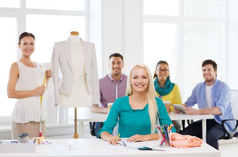 Lächelnde Modedesigner, die im Büro arbeiten lizenzfreie stockbilder Lächelnde Modedesigner, die im Büro arbeiten lizenzfreie stockbilder