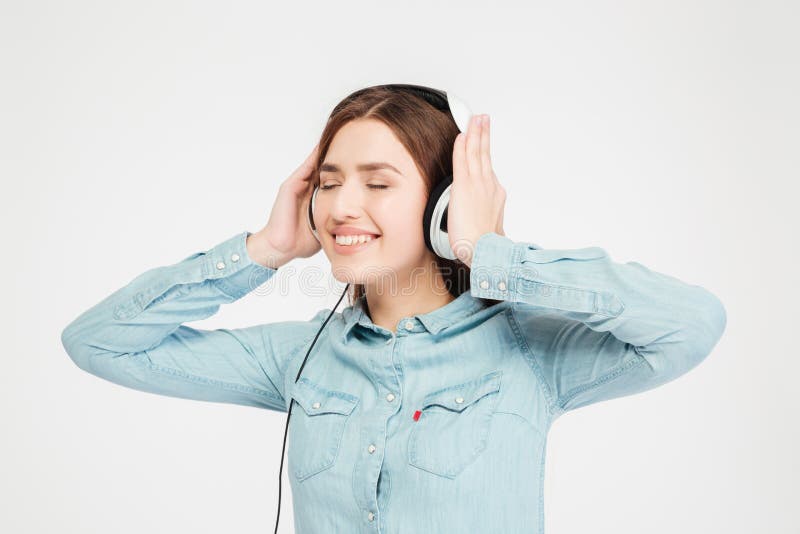 Lächelnde nette reizende Frau, die Kopfhörer verwendet und Musik hört stockbilder Lächelnde nette reizende Frau, die Kopfhörer verwendet und Musik hört stockbilder
