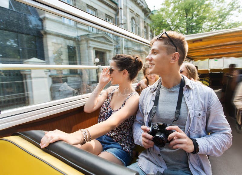 Lächelnde Paare mit der Kamera, die mit dem Reisebus reist lizenzfreie stockfotos Lächelnde Paare mit der Kamera, die mit dem Reisebus reist lizenzfreie stockfotos