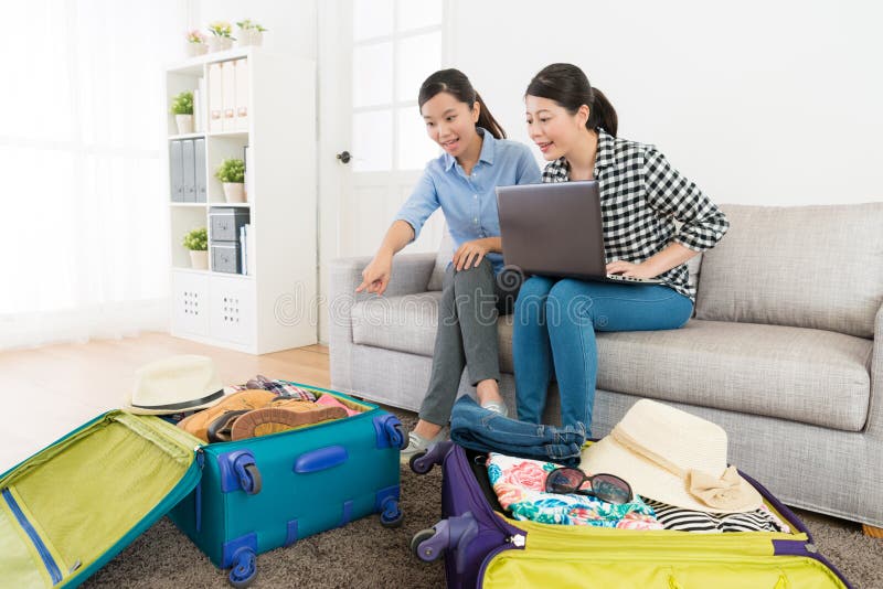 Lächelnde Schönheitsfreundinnen, die auf Sofacouch sitzen stockfoto Lächelnde Schönheitsfreundinnen, die auf Sofacouch sitzen stockfoto