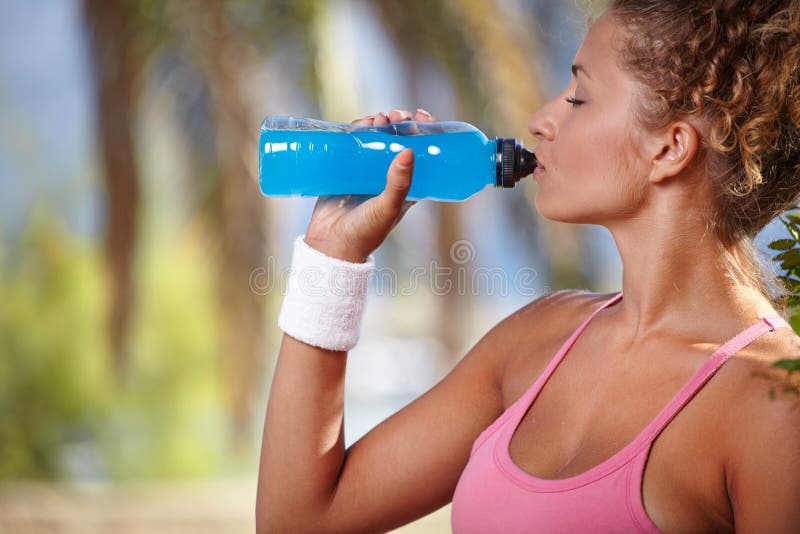 Lächelnde sportliche Frau mit Flasche Wasser lizenzfreie stockbilder Lächelnde sportliche Frau mit Flasche Wasser lizenzfreie stockbilder