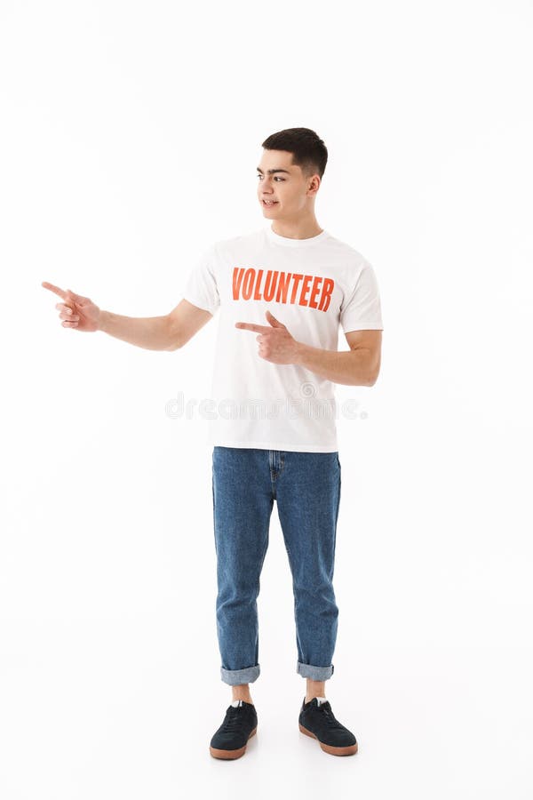 Lächelnde tragende freiwillige Stellung T-Shirt des jungen Mannes stockfoto Lächelnde tragende freiwillige Stellung T-Shirt des jungen Mannes stockfoto