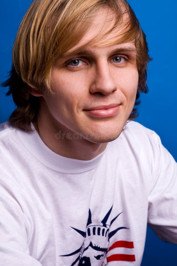 Lächelnder blonder Mann im weißen T-Shirt lizenzfreie stockbilder Lächelnder blonder Mann im weißen T-Shirt lizenzfreie stockbilder