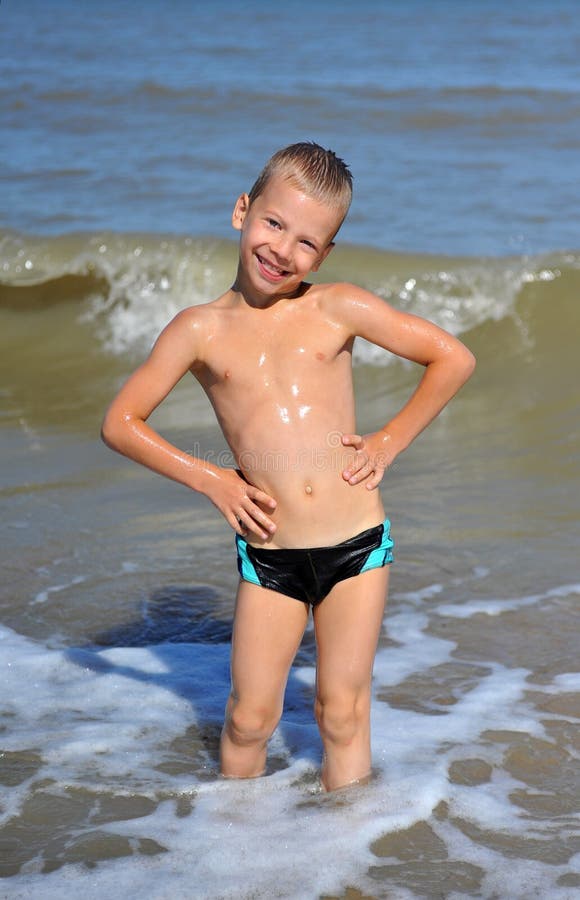 Lächelnder Junge, der im Wasser steht lizenzfreies stockfoto Lächelnder Junge, der im Wasser steht lizenzfreies stockfoto