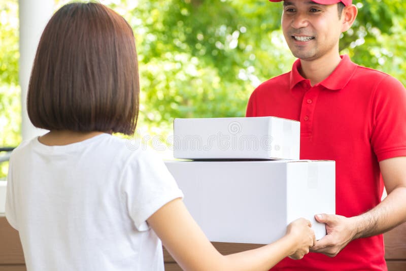 Lächelnder Lieferer, der Pakete an eine Frau liefert stockbild Lächelnder Lieferer, der Pakete an eine Frau liefert stockbild