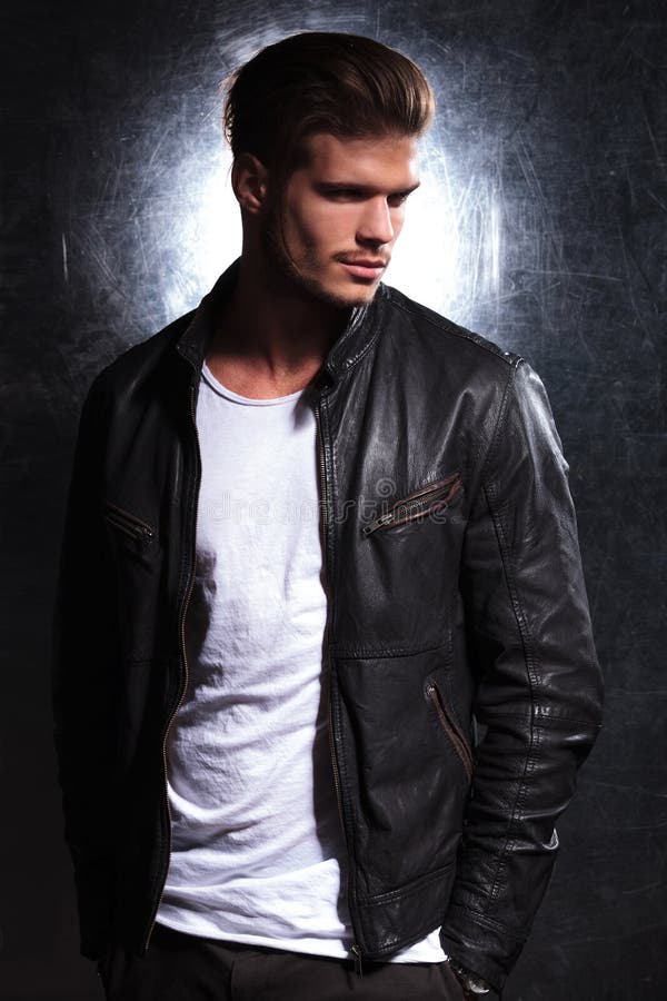 Lächelnder Modemann, der eine Lederjacke trägt stockfotografie Lächelnder Modemann, der eine Lederjacke trägt stockfotografie