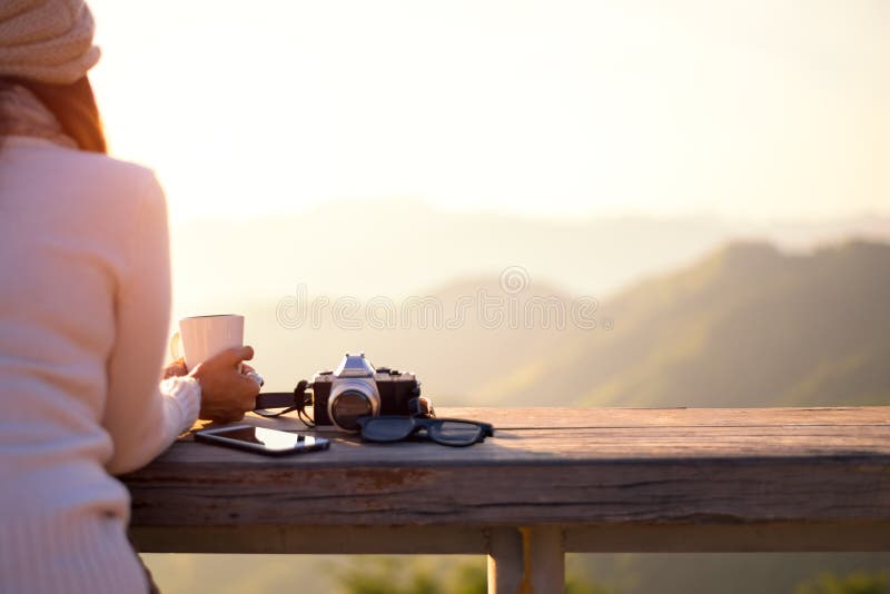 Lächelnder trinkender Kaffee und Tee der asiatischen Frau und machen ein Foto und entspannen sich beim Sonnensitzen im Freien im