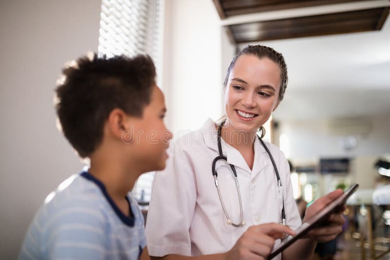 Lächelnder weiblicher Therapeut, der dem Jungen digitale Tablette zeigt stockbilder Lächelnder weiblicher Therapeut, der dem Jungen digitale Tablette zeigt stockbilder