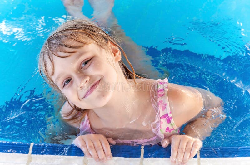 Lächelndes kleines blondes Mädchen in einem Pool stockfotos Lächelndes kleines blondes Mädchen in einem Pool stockfotos