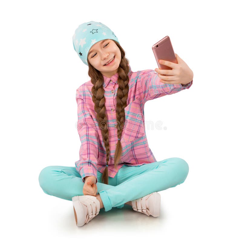 Lächelndes kleines Mädchen, das Handy und die Herstellung von selfie auf weißem Hintergrund hält stockbilder Lächelndes kleines Mädchen, das Handy und die Herstellung von selfie auf weißem Hintergrund hält stockbilder