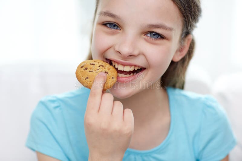 Lächelndes kleines Mädchen, das Plätzchen oder Keks isst