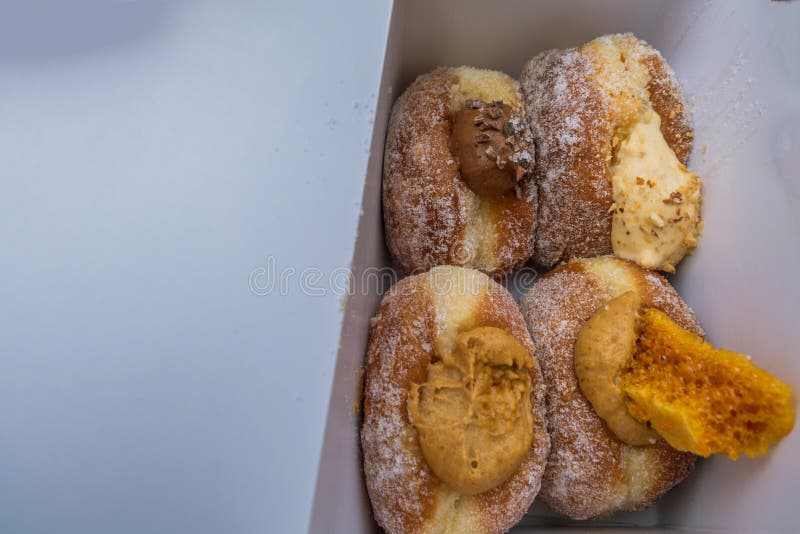 L?ckra s?ta donuts, kr?m- fyllning i en pappers- ask i marknadsbageri arkivbilder L?ckra s?ta donuts, kr?m- fyllning i en pappers- ask i marknadsbageri arkivbilder